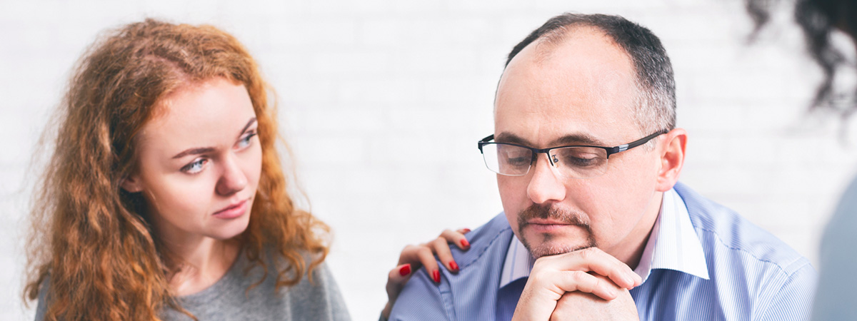  Supportive wife comforting husband with TRD during a meeting with a counselor in Roswell.