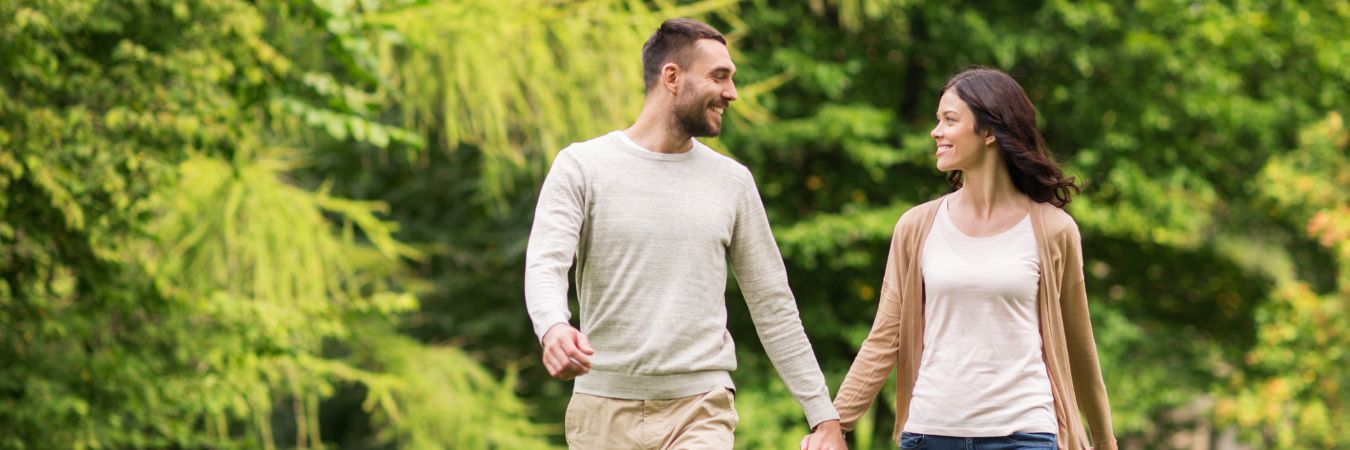 A couple walking hand in hand at a park during summer season enjoying life after rehab in Roswell
